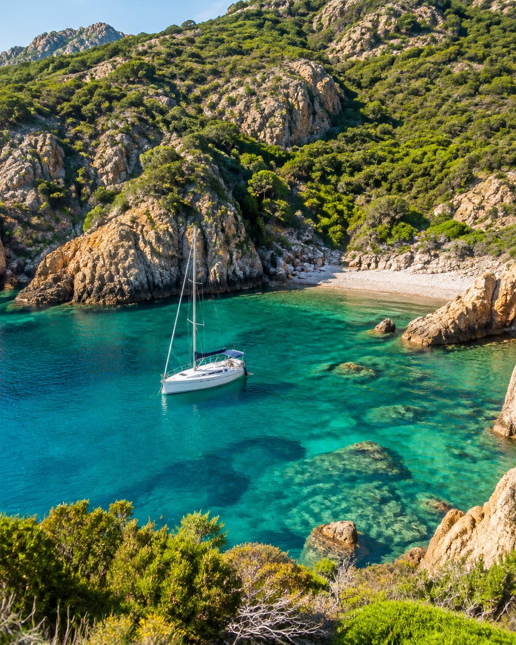 Catamaran anchored in a turquoise cove in Corsica